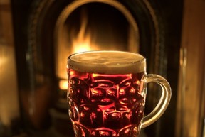 A mug of beer in front of an open fire.