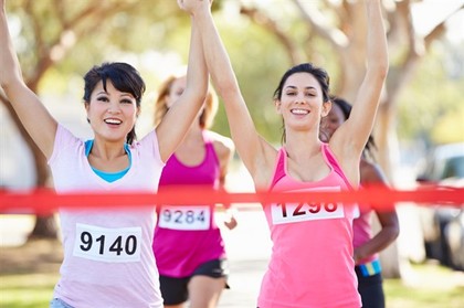 A group of happy marathon runners crossing the finish line.