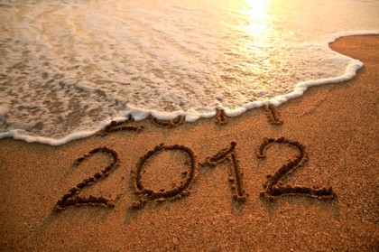 An area of sand near the sea containing the writing 2012.