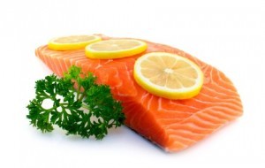 A piece of raw salmon garnished with lemon and parsley.