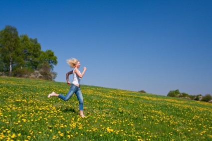A woman running in a sunny meadow.