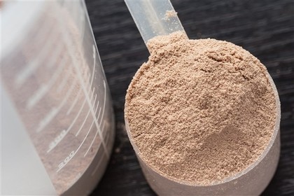A scoop of chocolate flavoured protein powder.