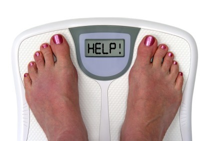 Two feet on a set of weighing scales with the message help.