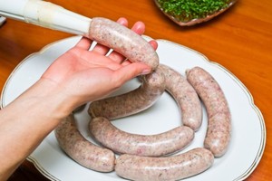 A selection of natural beef sausages on a white plate.