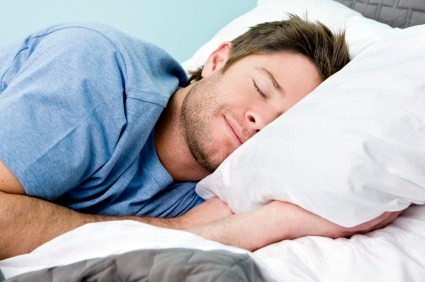 A man smiling and sleeping.