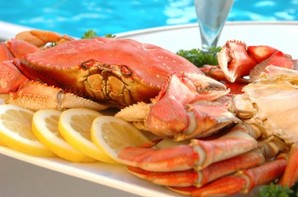 A crab with slices of lemon beside a pool.