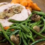 A slice of turkey with a selection of vegetables.