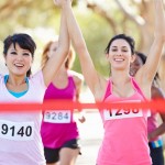 A group of happy marathon runners crossing the finish line.